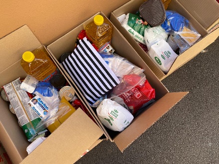 Open boxes of groceries packed for delivery — cooking oil and household essentials